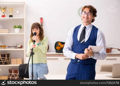 Young woman during music lesson with male teacher