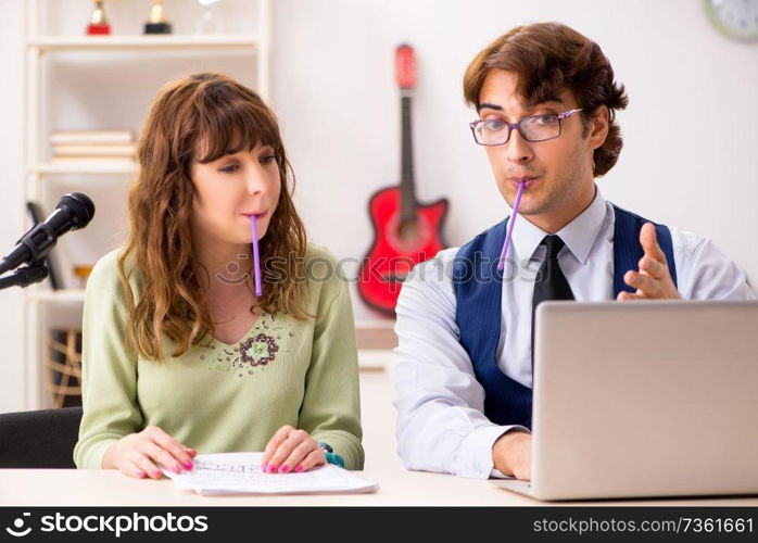 Young woman during music lesson with male teacher