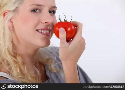 Young woman eating a tomato