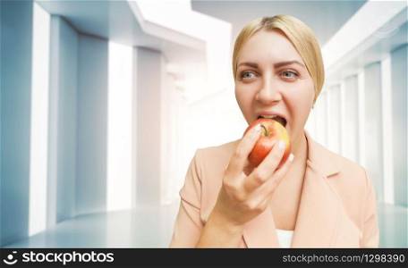 Young woman eating an apple over abstract background. Woman eating an apple