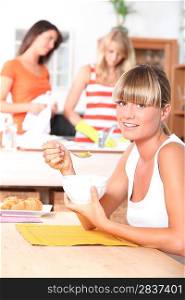 Young woman eating breakfast with friends
