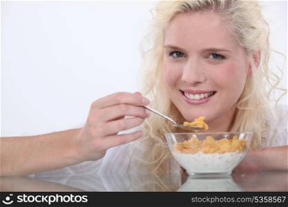Young woman eating cereals with milk