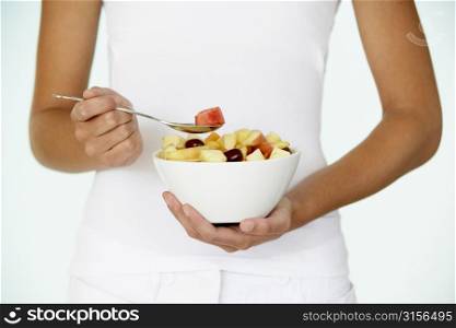 Young Woman Eating Fresh Fruit Salad