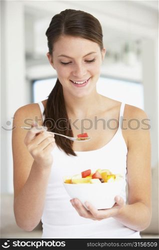 Young Woman Eating Fresh Fruit Salad