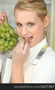 Young woman eating grapes