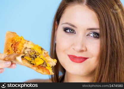 Young woman eating hot fresh pizza slice, on blue. Delicious fast food meal. People, italian cuisine concept.. Woman eating hot pizza slice