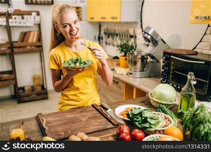 Young woman eating on the kitchen, healthy eco food. Vegetarian diet, fresh vegetables and fruits. Young woman eating healthy eco food