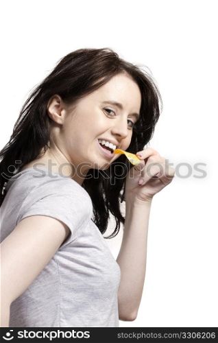 young woman eating potato chip. young woman from side eating potato chip with a smile
