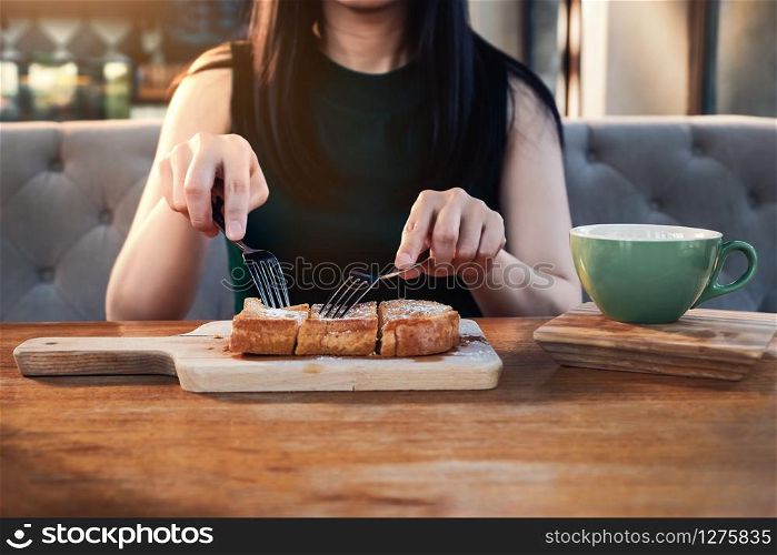 Young Woman Eating Sweet Dessert in Cafe or Restaurant. Front View. Cropped Image