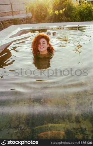 Young woman enjoying a summer day in a natural pool