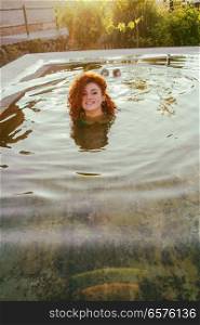 Young woman enjoying a summer day in a natural pool