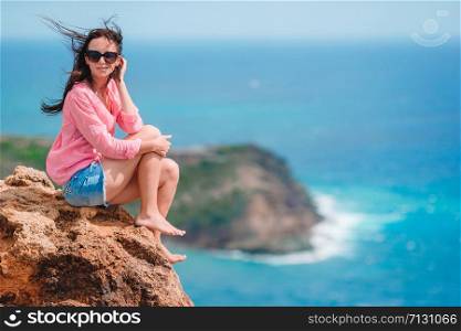 Young woman enjoying breathtaking views of beautiful landscape of tropical island. Young woman enjoying breathtaking views of beautiful landscape
