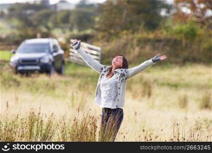 Young Woman Enjoying Freedom Outdoors in Autumn Landscape