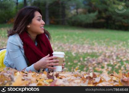 Young woman enjoying her beverage outdoors during autumn