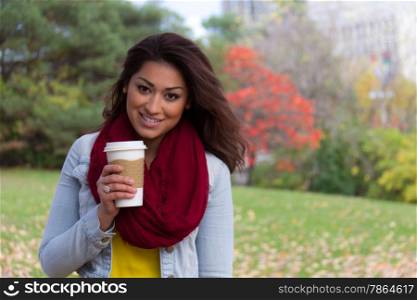 Young woman enjoying her beverage outdoors during fall