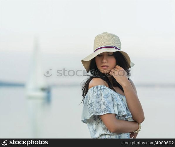 Young woman enjoying morning on tropical beach with yacht on background