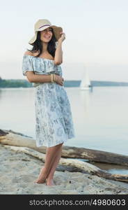 Young woman enjoying morning on tropical beach with yacht on background