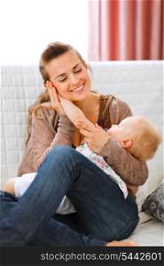 Young woman enjoying of being mother put baby&rsquo;s hand to her cheek &#xA;