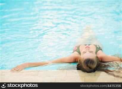 Young woman enjoying pool . rear view