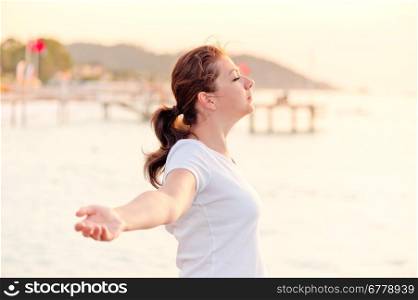young woman enjoying the freedom with open arms