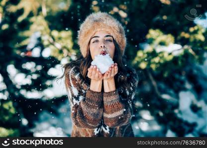 Young woman enjoying the snowy mountains in winter, in Sierra Nevada, Granada, Spain. Female wearing winter clothes playing with snow.. Young woman enjoying the snowy mountains in winter