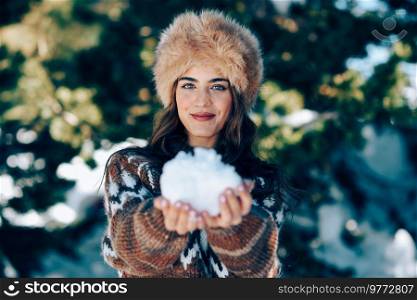 Young woman enjoying the snowy mountains in winter, in Sierra Nevada, Granada, Spain. Female wearing winter clothes playing with snow.. Young woman enjoying the snowy mountains in winter