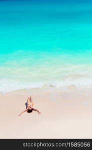 Young woman enjoying the sun sunbathing by perfect turquoise ocean on white beach. Young woman enjoying the sun sunbathing by perfect turquoise ocean