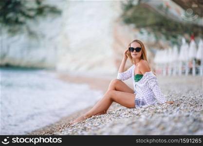 Young woman enjoying the sun sunbathing on the beach. Young woman enjoying the sun sunbathing by perfect turquoise ocean