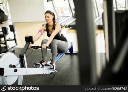 Young woman exercises on an exercise machine at themodern gym