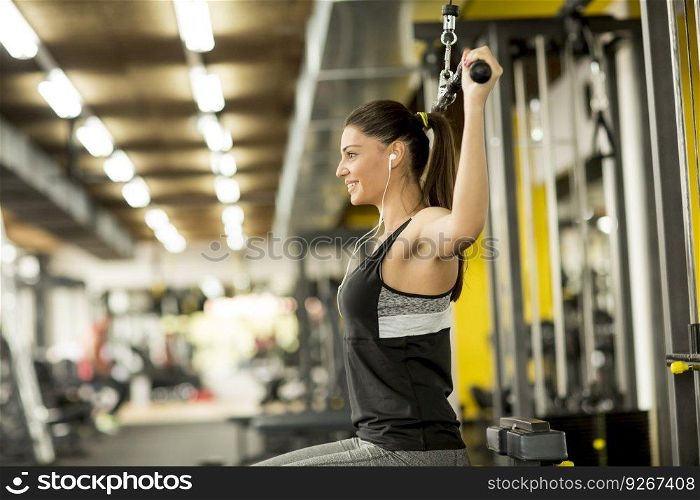 Young woman exercises on an exercise machine at themodern gym