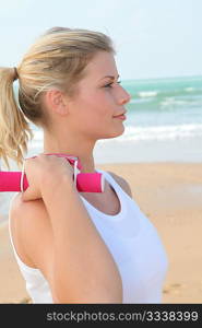 Young woman exercising by the beach