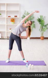 Young woman exercising in sports hall in healthy concept