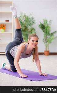Young woman exercising in sports hall in healthy concept