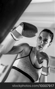 Young woman exercising in the gym on punching bag