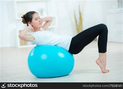 young woman exercising using a gym ball