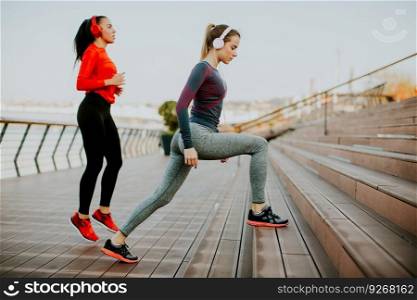 Young woman exercising with a personal trainer outside in the morning
