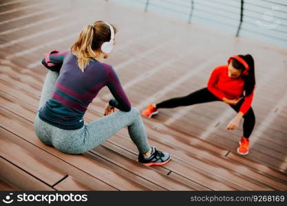 Young woman exercising with a personal trainer outside in the morning