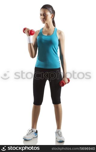 Young woman exercising with dumbbells isolated over white background