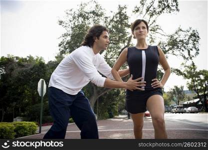 Young woman exercising with physical trainer