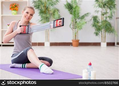 Young woman exercising with resistance band in gym