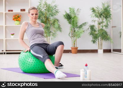 Young woman exercising with stability ball in gym