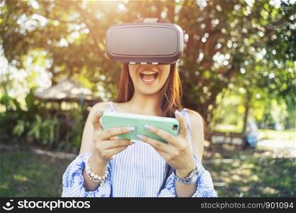 Young woman exited when using VR headset with mobile. Technology for life concept.