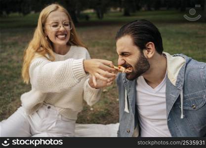 young woman feeding pizza her boyfriend