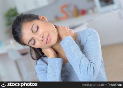 young woman feeling exhausted and suffering from neck pain