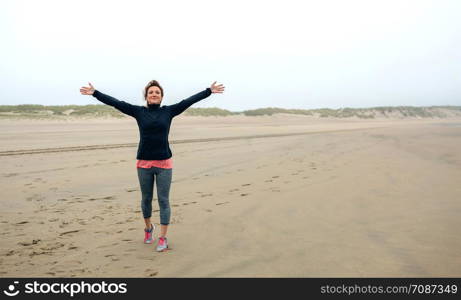 Young woman feeling free on the beach in autumn. Young woman feeling free on the beach