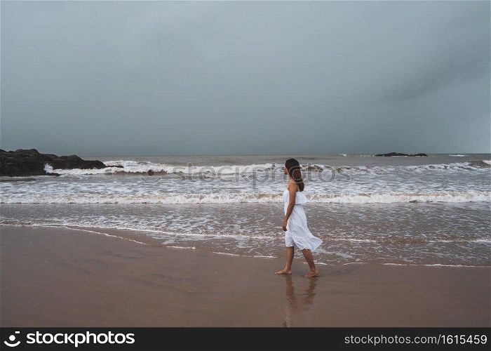 Young woman feeling lonely and sad looking at the sea on a gloomy day