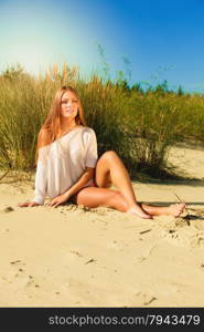 Young woman female model in full length posing outdoor on background of dunes sky and grass