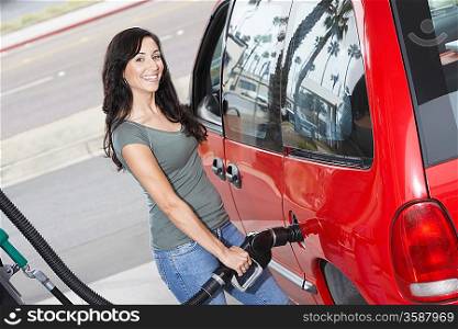 Young Woman Filling Up at the Gas Station