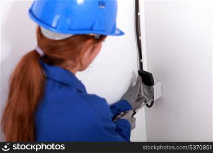 Young woman fitting an electrical socket
