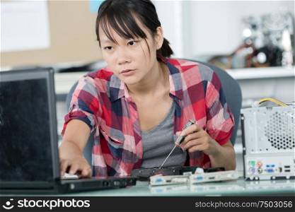 young woman fixing a computer